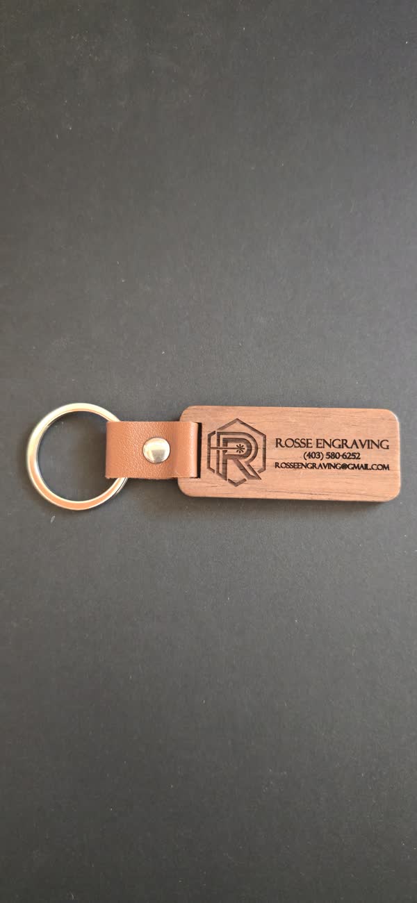 Wood and leather keychain engraved with the Rosse Engraving logo and contact details